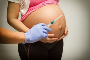 Pregnant woman with syringe ,Vaccinating A Pregnant Woman